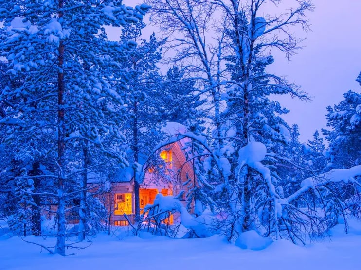 arctic hut covered in snow in finnish forest