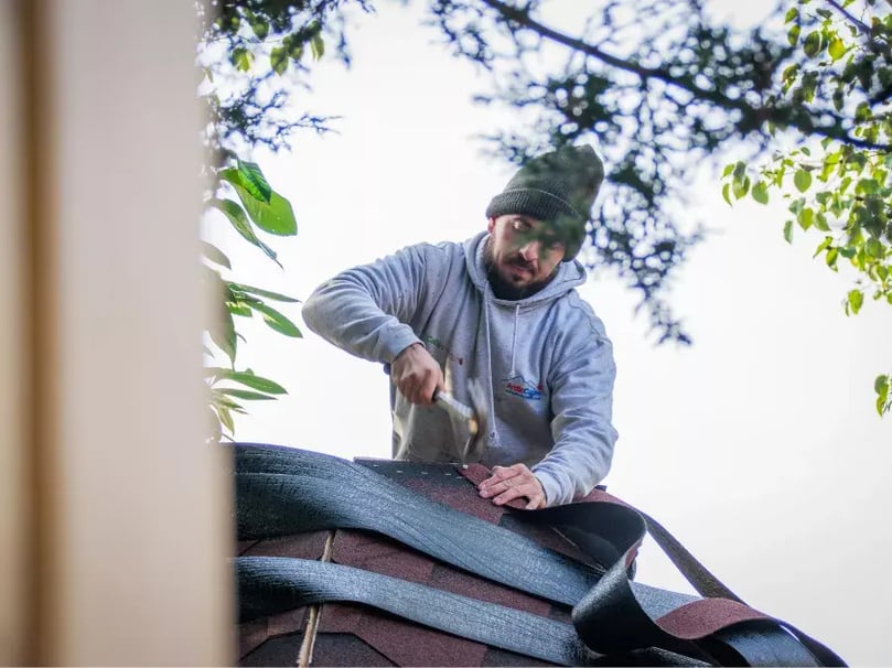 Arctic Cabins installer applying roof felt to BBQ hut, Nottingham show site