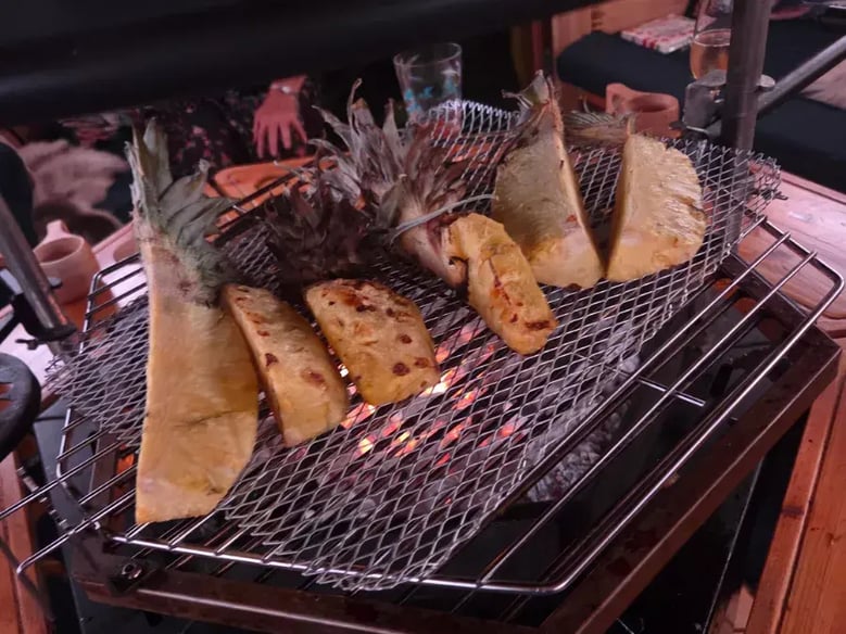 Grilled pineapple on the grill of a BBQ hut