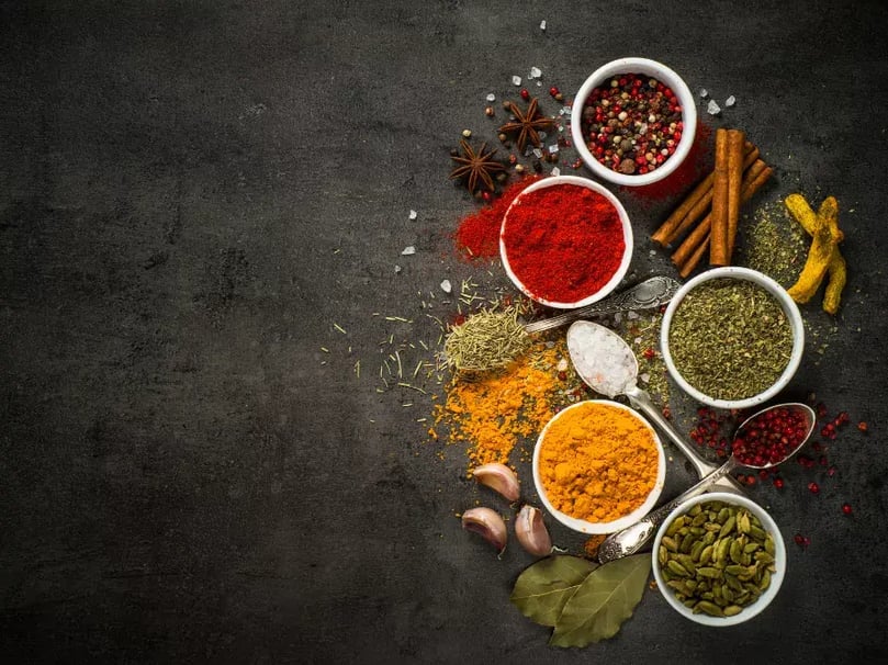 Selection of herbs & spices for BBQing, on wooden chopping board