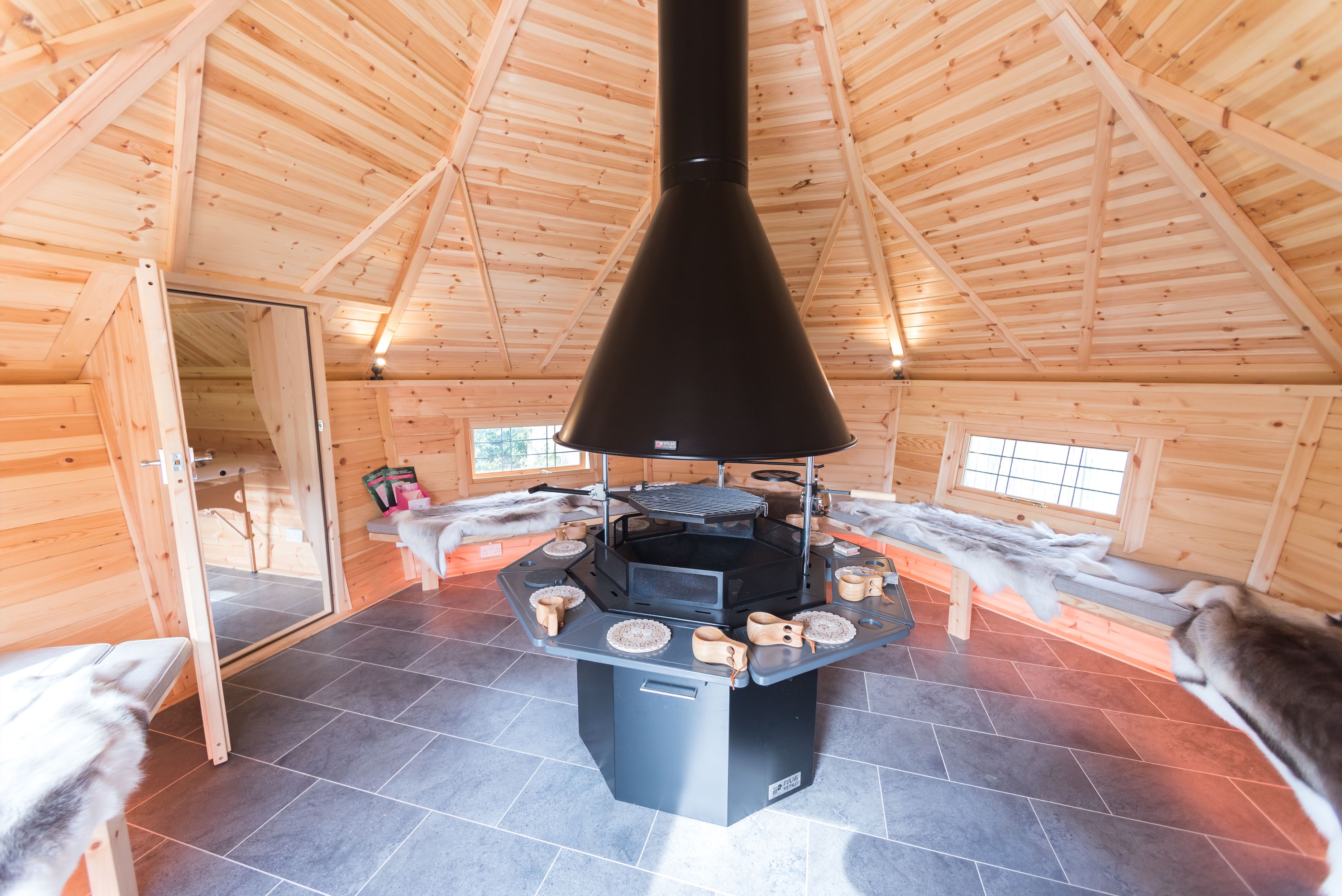A wellness BBQ cabin with a side extension leading to a treatment room.