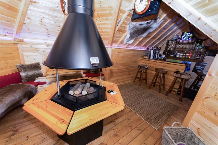 Looking from the doorway at an indoor BBQ grill and the bar behind.
