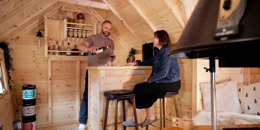 Couple enjoying drinks inside a 10m² barbecue hut with a Scandi-style bbq bar