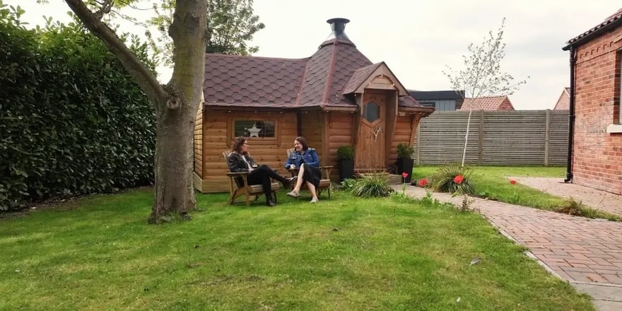 Exterior of a 10m² garden bar and barbecue hut in a landscaped garden