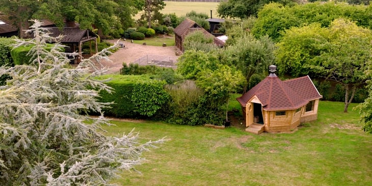 Aerial view of a 14m² Arctic Cabin with a customised extension in a spacious garden