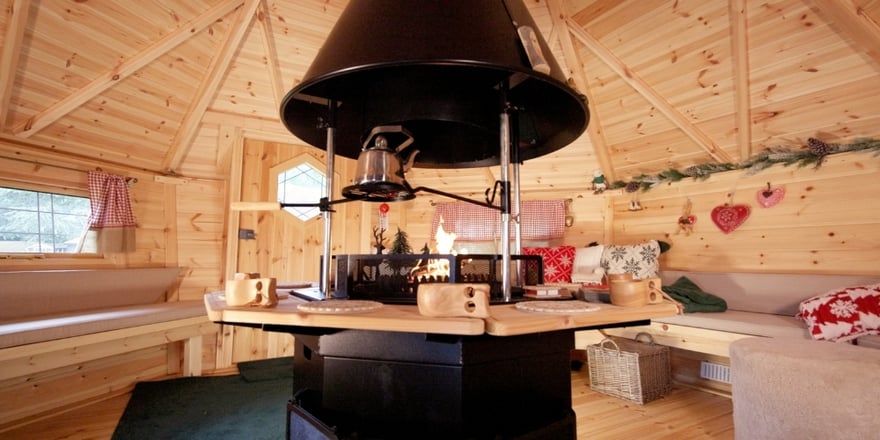 Mountain chalet-inspired cabin extension with a vista window, comfortable seating and alpine decorations
