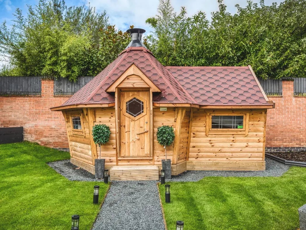 Scandinavian BBQ hut with traditional timber design and central chimney