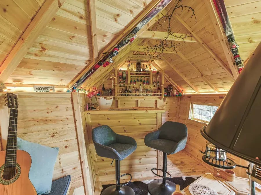 bar stools next to bar area inside a garden cabin