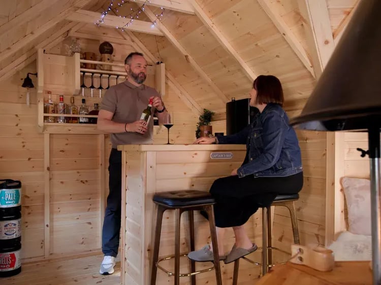 couple enjoying drink in their arctic cabin bar