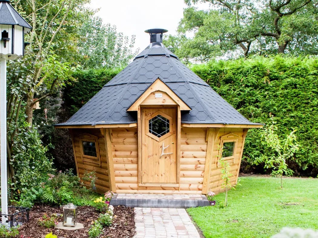 An Arctic Cabin BBQ hut in the corner of a garden.