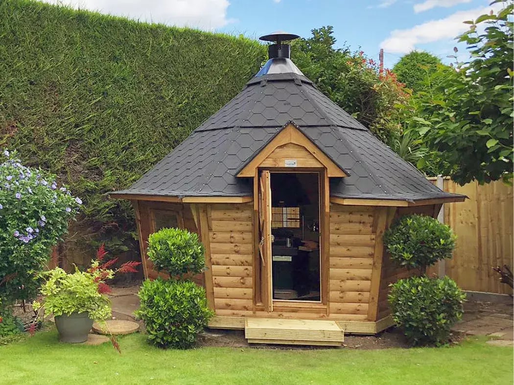 A 10m2 BBQ hut in the corner of a garden.