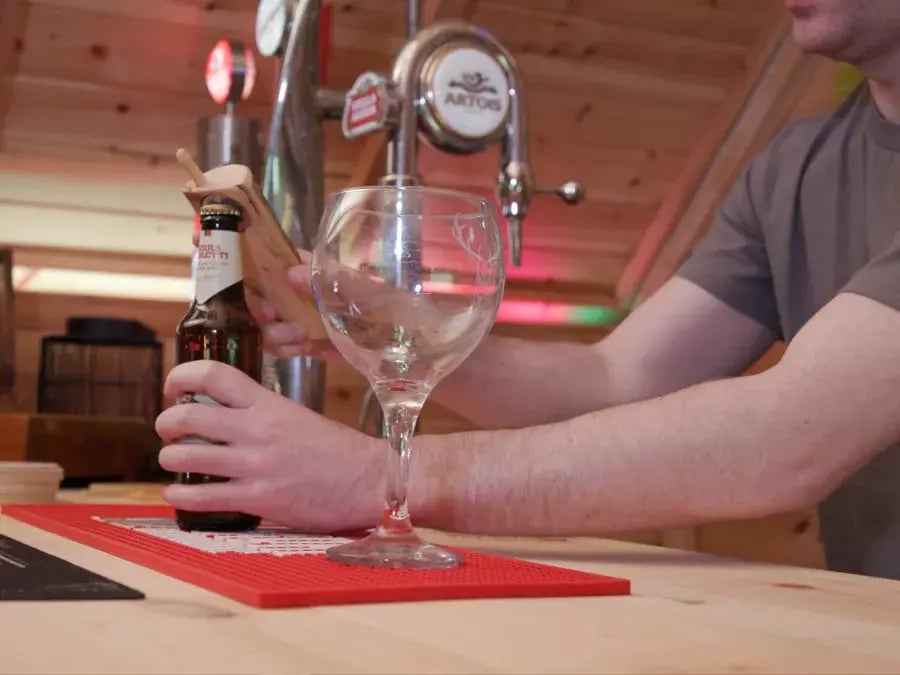 man serving beers inside cabin bar