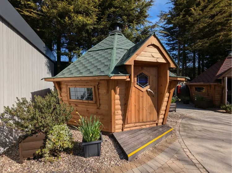 A 14m2 hexagonal BBQ log cabin with a green roof
