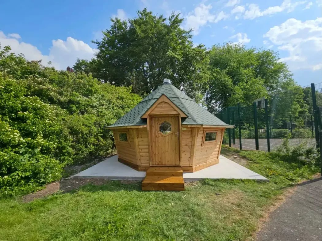 Outdoor BBQ hut with natural timber cladding, ideal for garden parties