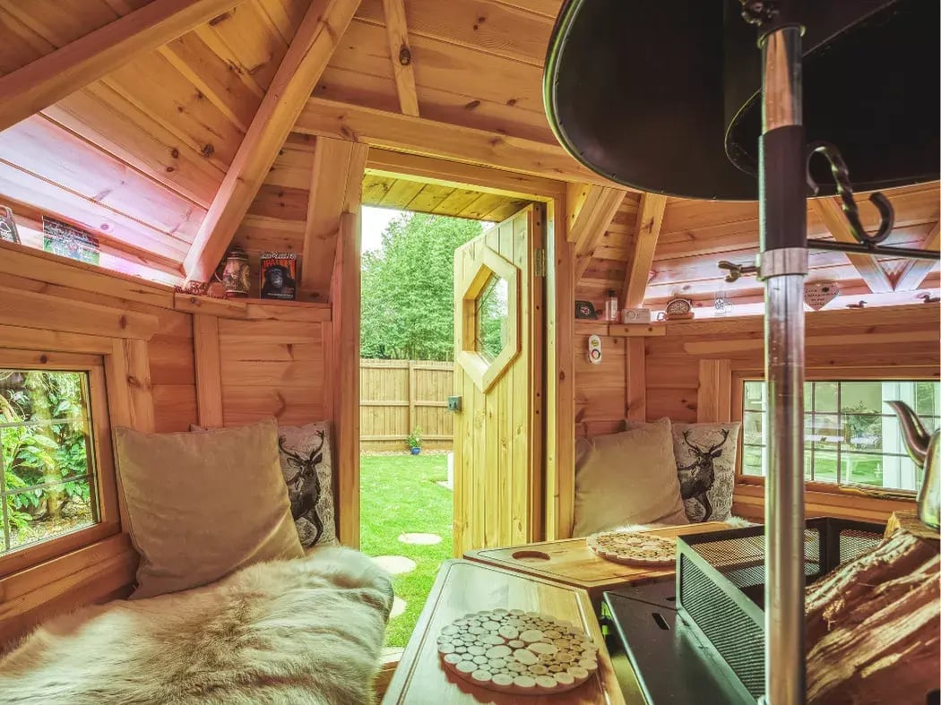 Inside a grill cabin with the door open looking out into a garden