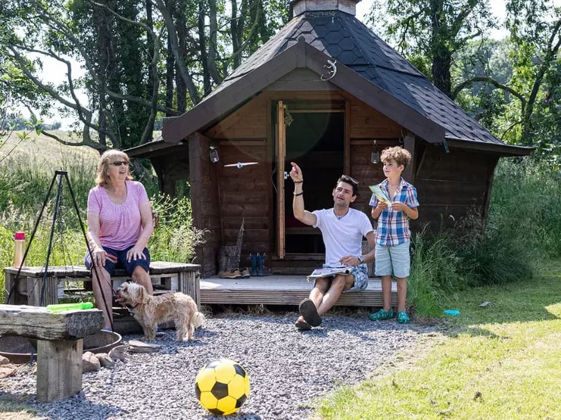 family playing outside an arctic cabin x