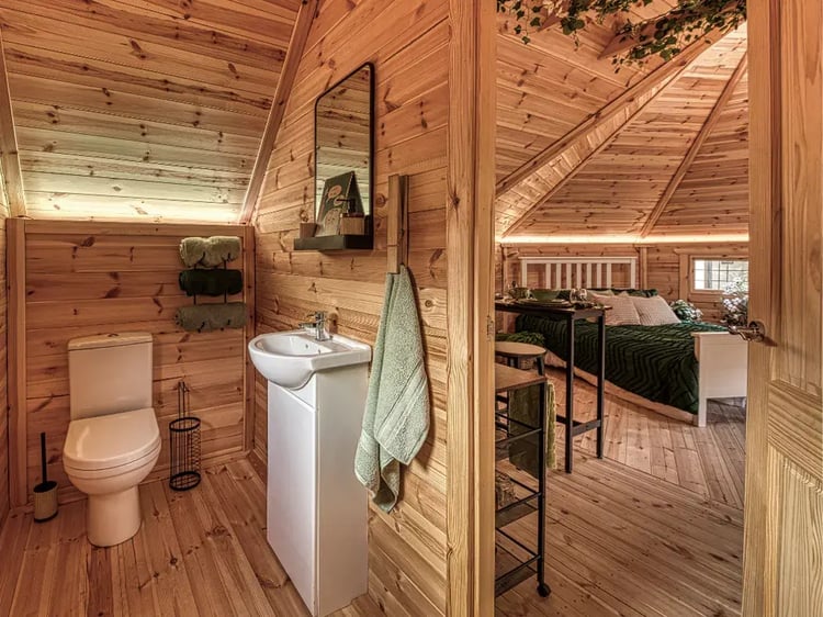Interior of Timber Cabin Bedroom with bed, chairs & decor