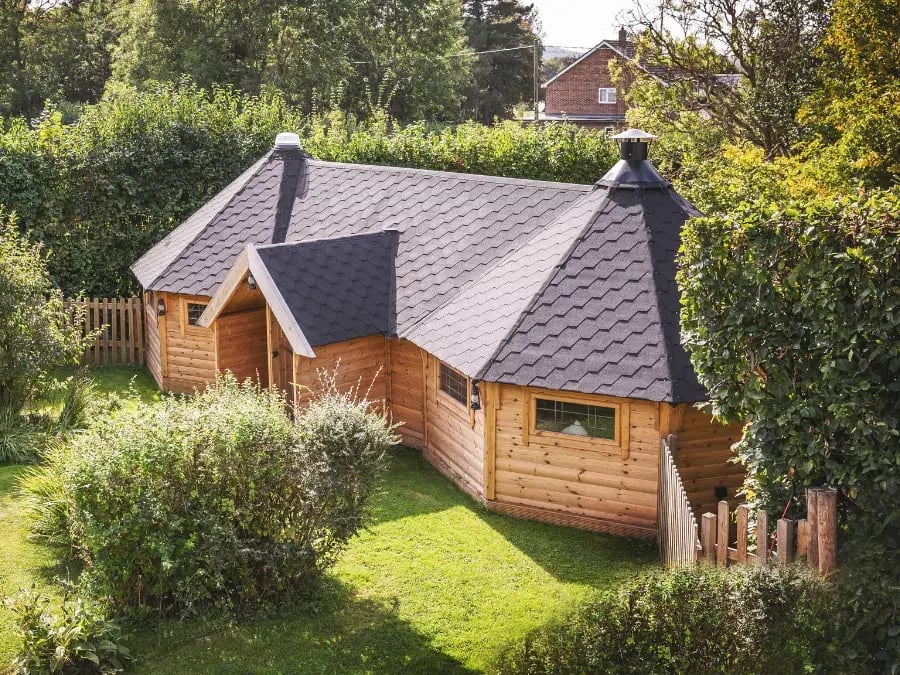 Large linked BBQ huts UK with central grill and garden bar area for outdoor entertaining