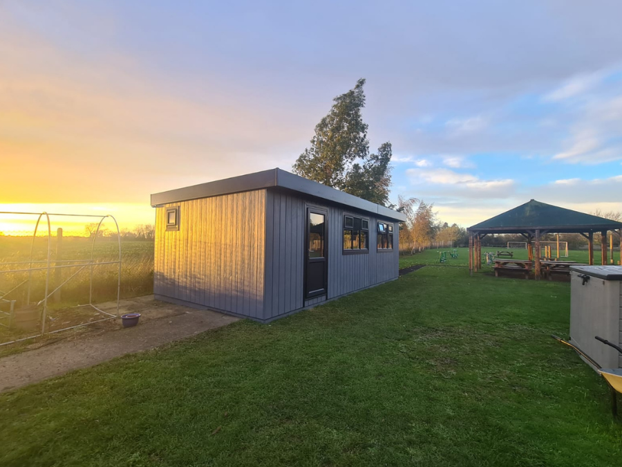 outdoor classroom with no maintenance dark grey cladding on field of a school