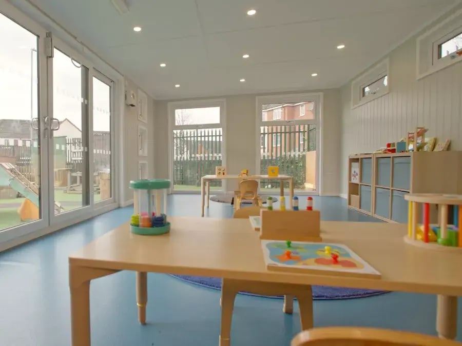 inside of a garden room classroom set up with tables and chairs