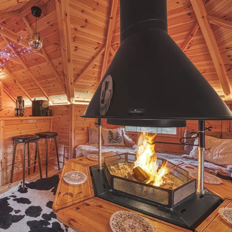 inside a garden bar hut with barbecue in the middle
