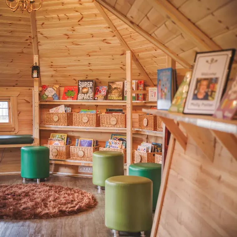 Inside Garden Cabin for children, with shelves of books