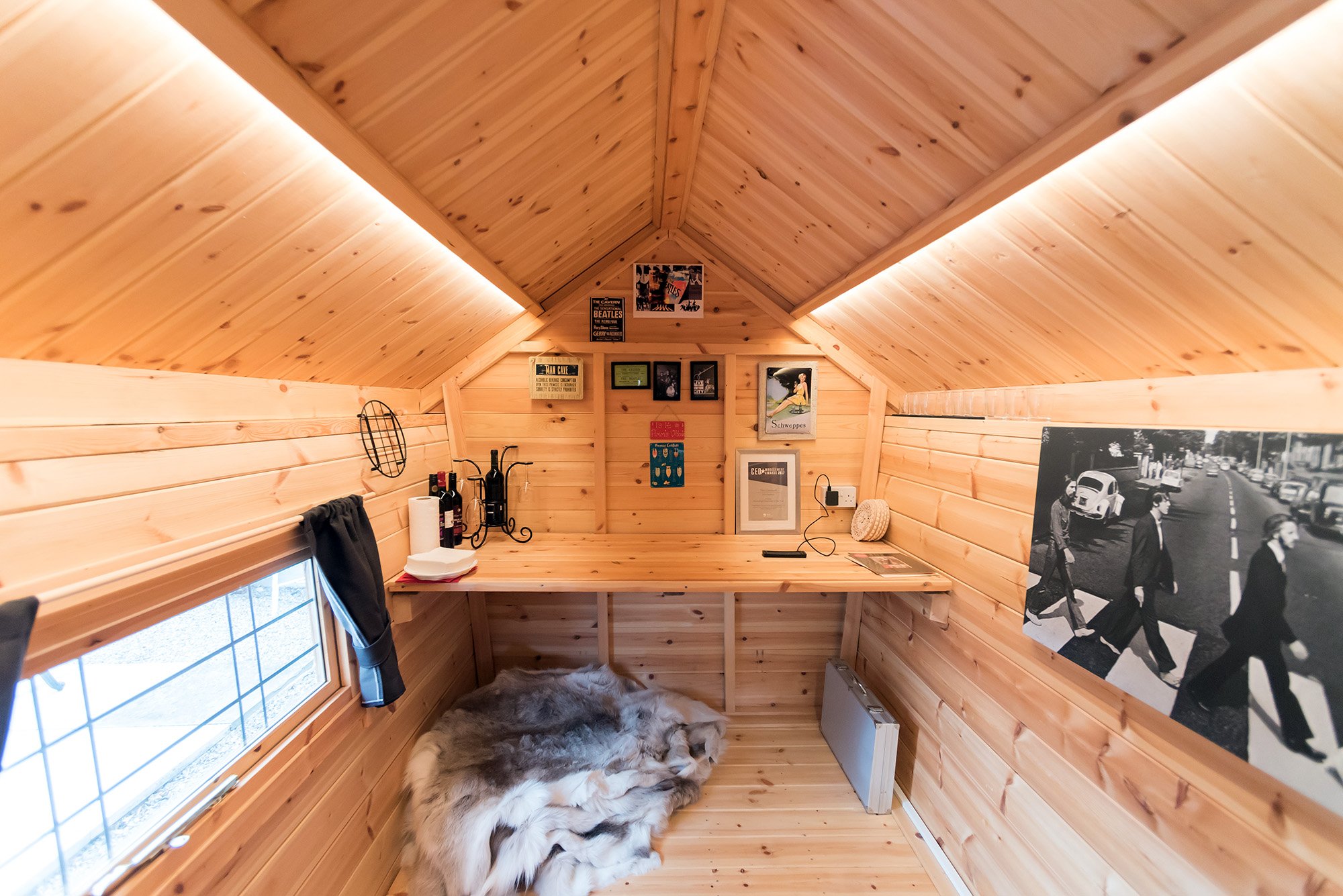 Interior or Timber cabin garden office with desk, pictures and rugs
