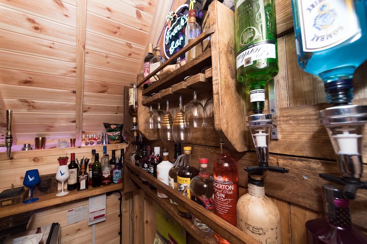 Close up of Arctic Bar drinks rack, with spirits, glasses and neon bar sign