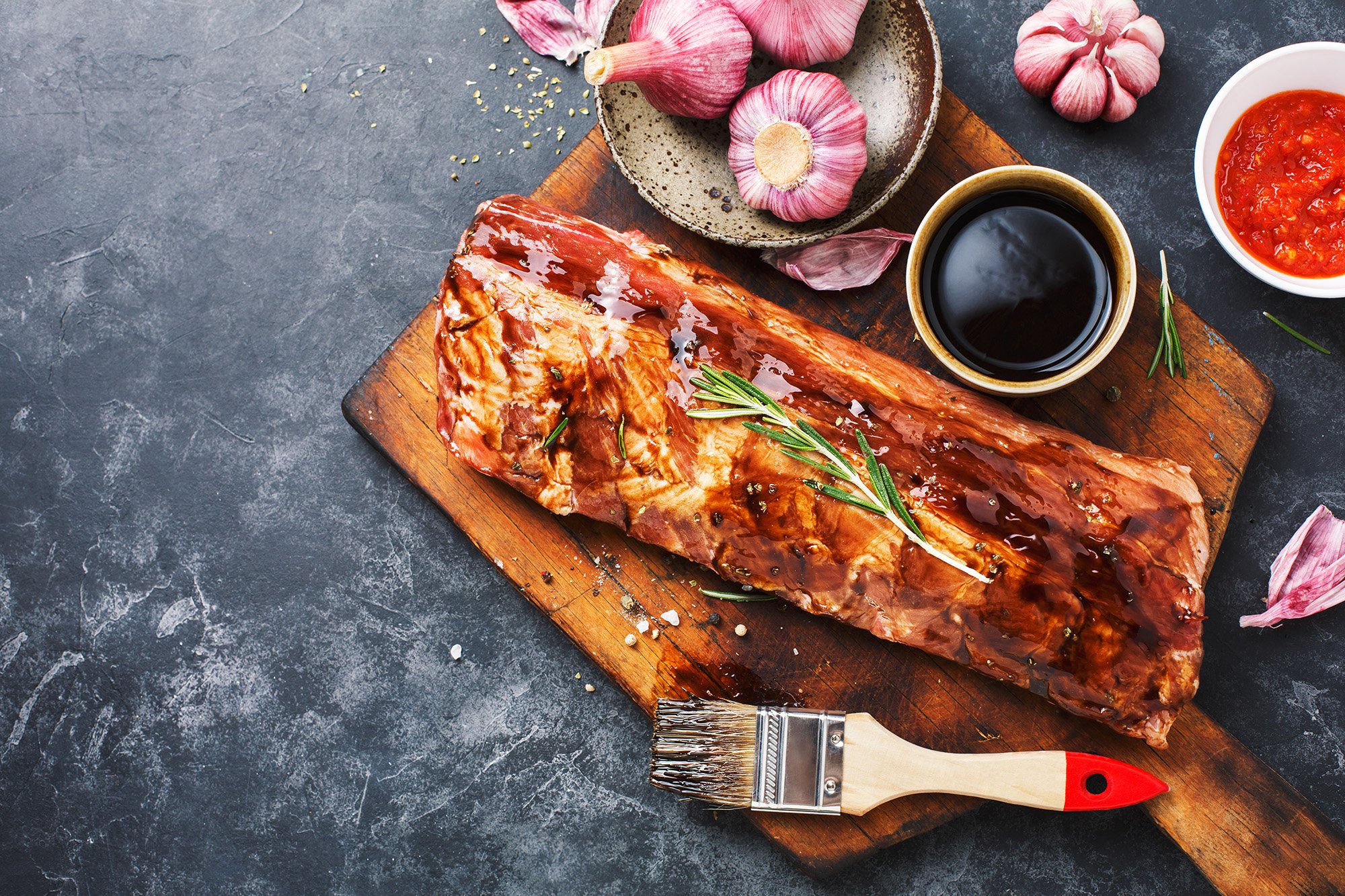 Meat marinade and ingredients on wooden chopping board