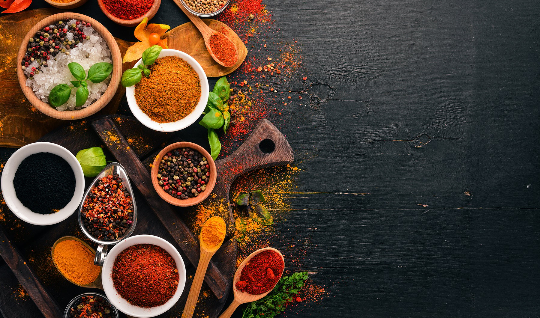 Top down image of herbs and spices on wooden chopping board