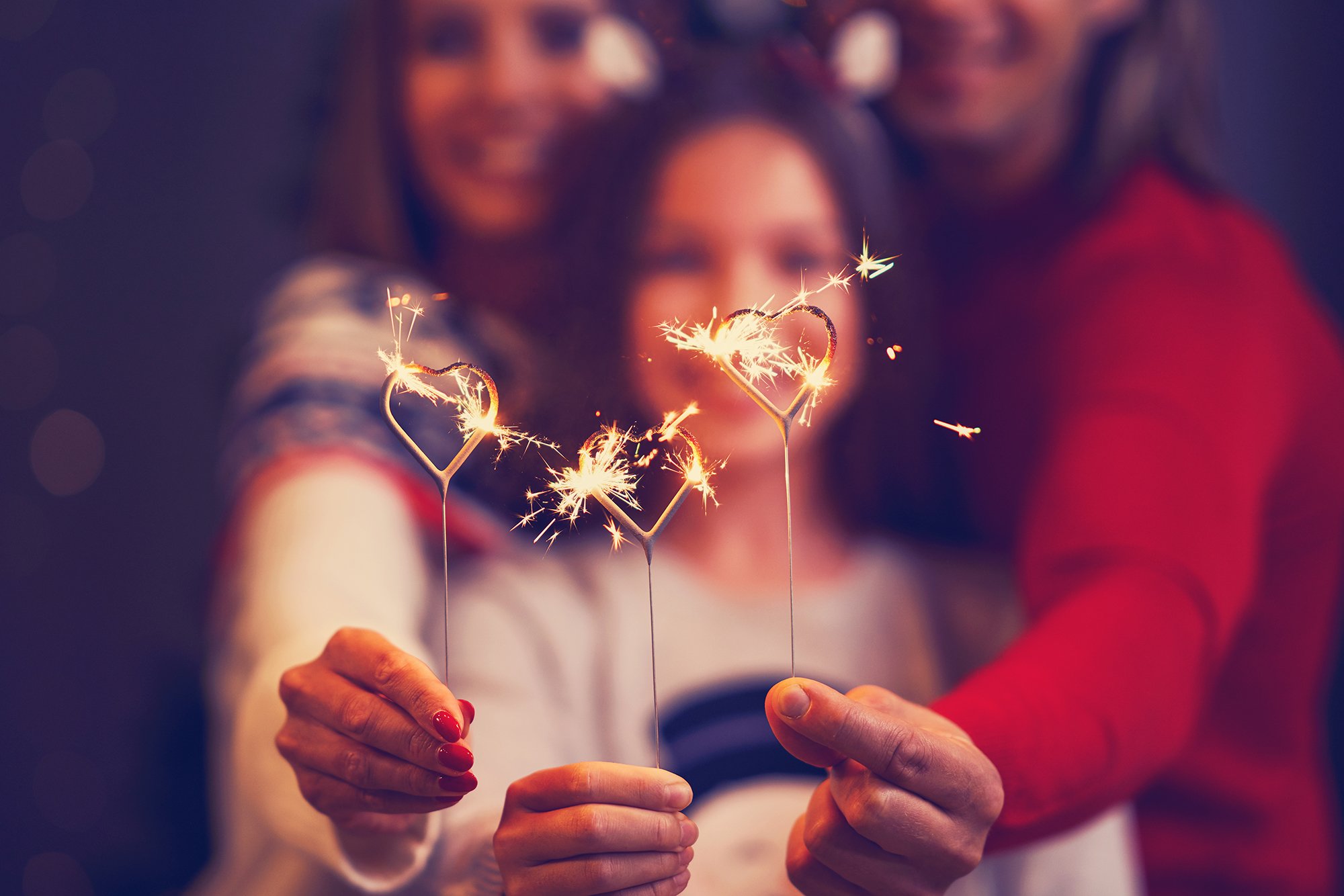 Family holding heart shaped Xmas sparklers