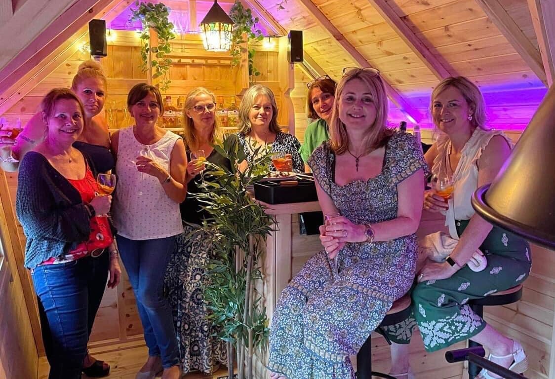 Group of women enjoying drinks inside an Arctic Cabins garden bar