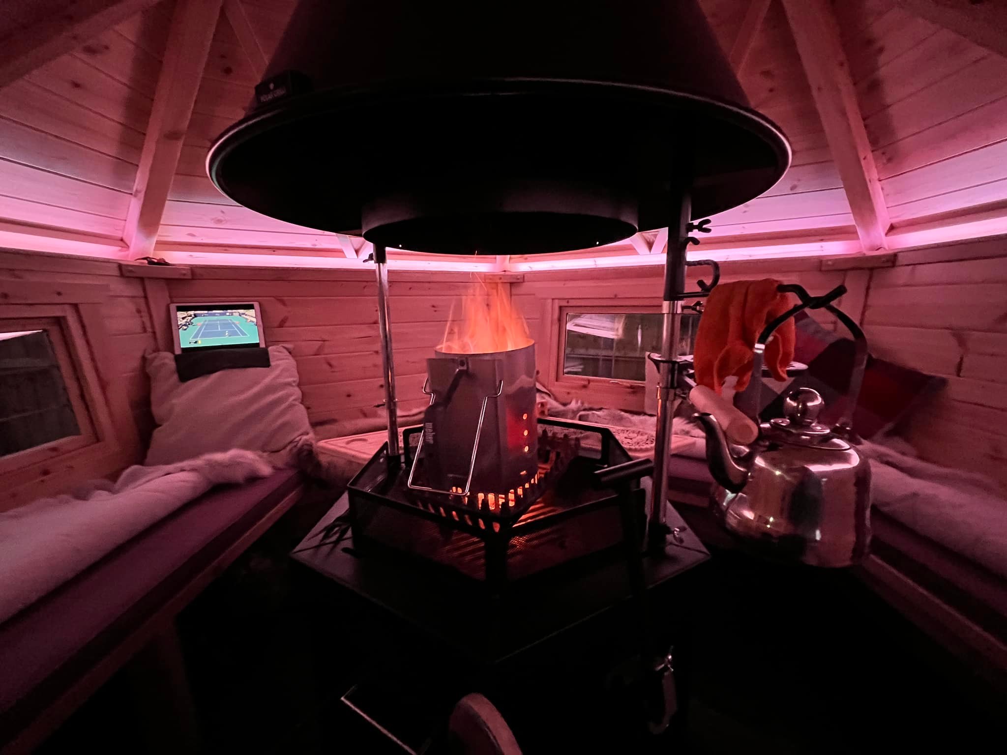Lit BBQ with firebasket inside an Arctic Cabin timber BBQ House