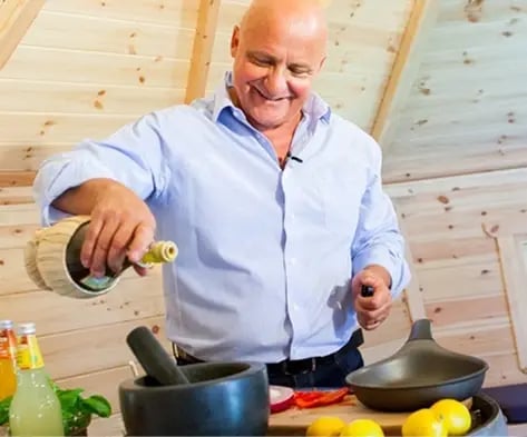 Aldo Zilli cooking in a large Scandinavian grill cabin
