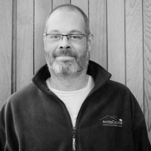 Black & White photo of Gareth Parkinson MD at Arctic Cabins in front of a cedar garden room by sister company Cabin Master