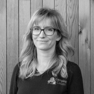 Black & White photo of Anne-Marie Adams, Sales Executive at Arctic Cabins in front of a cedar garden room by sister company Cabin Master