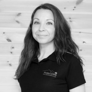 Black & White photo of Virpi Kokko at Arctic Cabins in front of a redwood garden room by sister company Cabin Master
