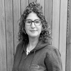 Black & White photo of Kay Pollard, Digital Marketing Executive at Arctic Cabins in front of a cedar garden room by sister company Cabin Master